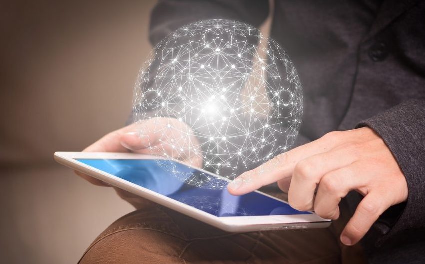 a tablet being held with a hologram of a sphere floating above the screen